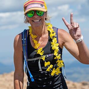 Woman hiker at the summit of Pikes Peak giving the sign for "peace".