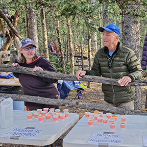 Two volunteers at a water and snack table at Barr Camp